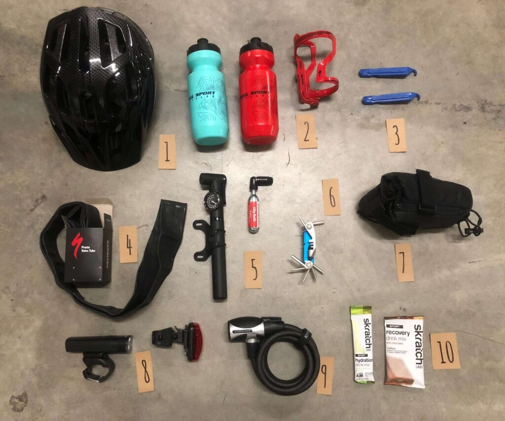 Complete cycling accessories kit including helmet, water bottles, bike tools, saddle bag, and maintenance equipment